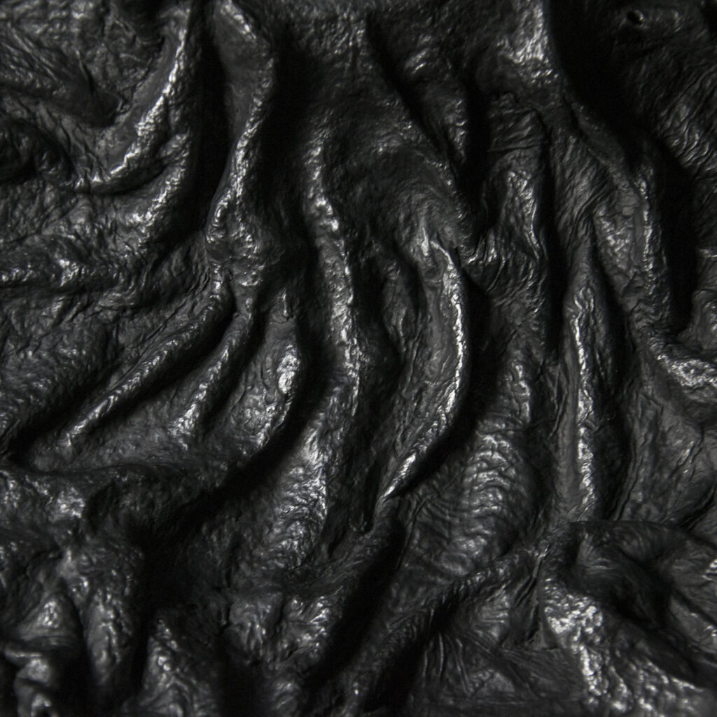Hand-shaped material surface exploring geological forms.