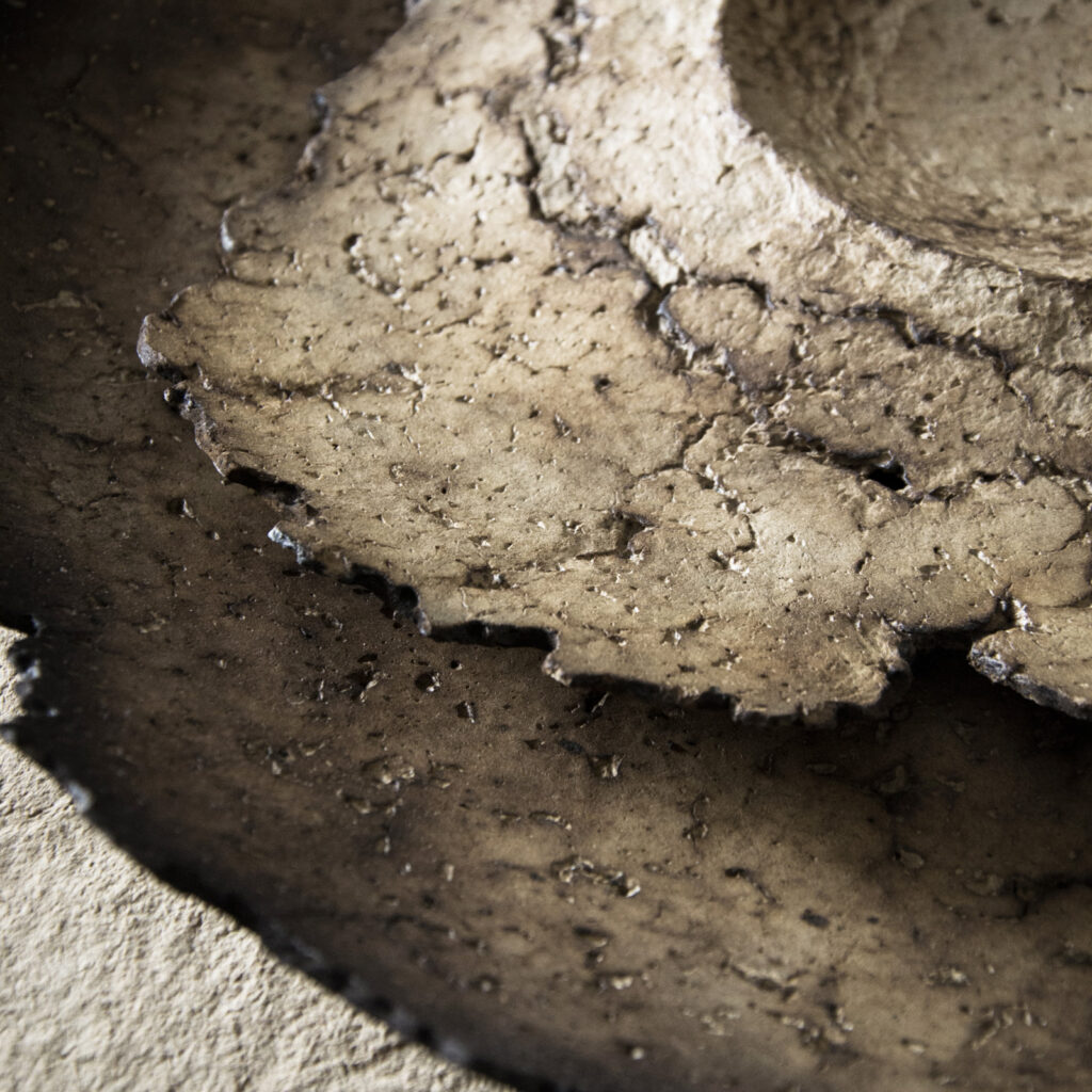 Hand-shaped material surface exploring geological forms.