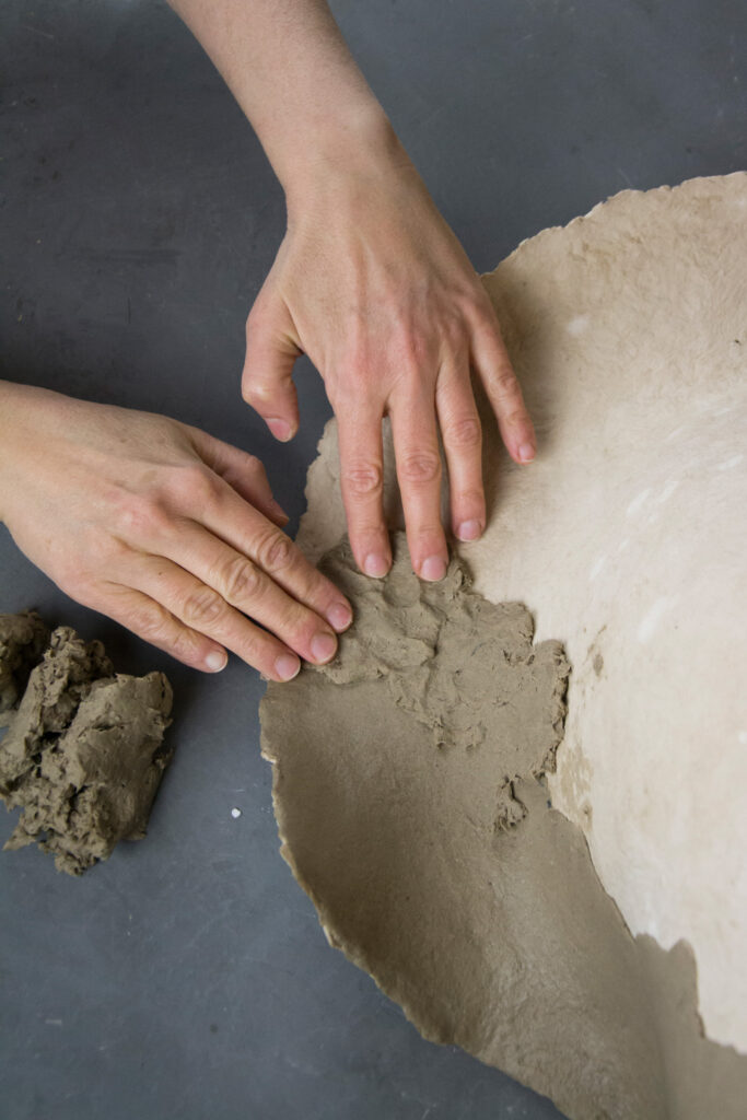 Artist refining sculptural surfaces by hand.