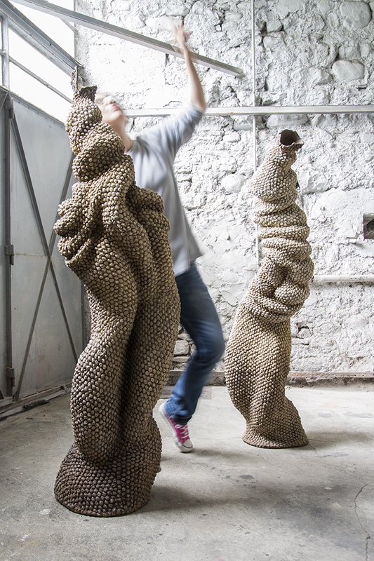 Artist in the studio with monumental sculptures