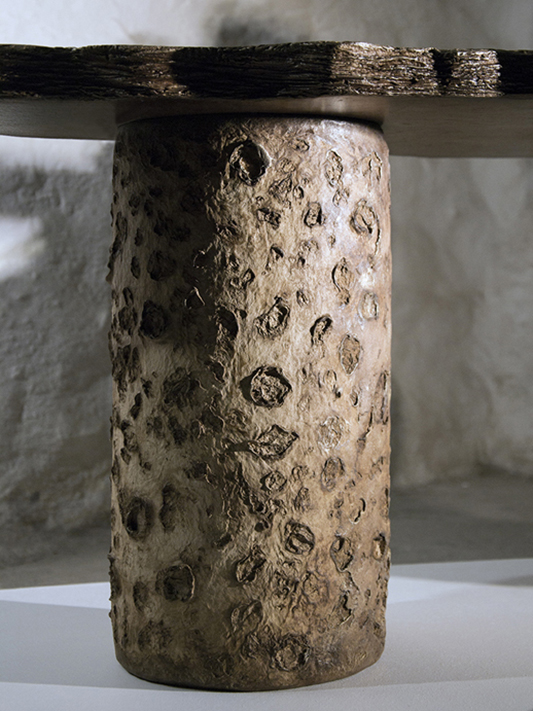 Material relief evoking lunar textures and cosmic formations.
